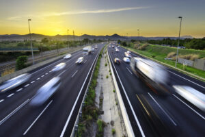 Busy highway at sunset, vehicles coming and going, city stress –