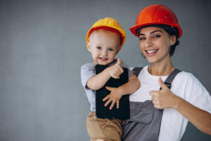 Mother with little boy builders wearing orange helmets